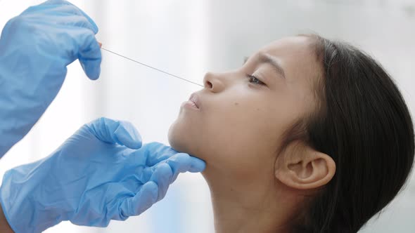 Close Up View of Medical Worker in Protective Gloves Taking Swab From Nose of Little Girl