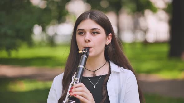 A Girl Plays the Clarinet in the Park