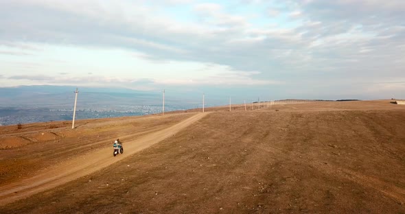 A man rides motorcycle aerial follow shot