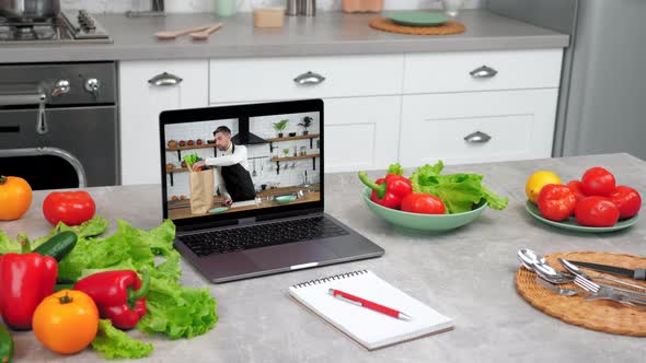 Man Chef in Laptop Computer Screen Tells Removes Vegetables From Paper Bag