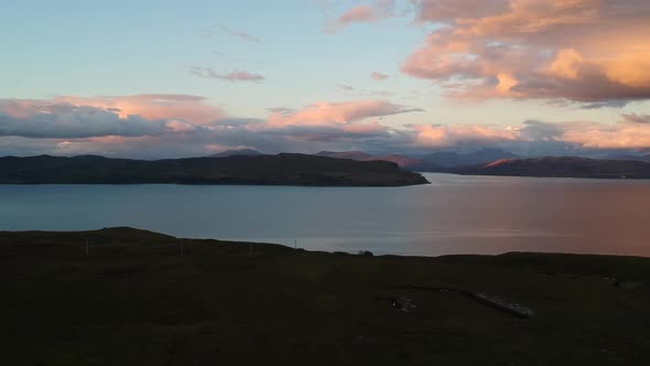 Golden hour panning drone shot of Scottish mountain lake.  Aerial video shot by a drone. Scotland