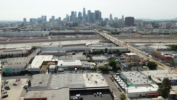 Rising over the industrial district a nd warehouses of Los Angeles to reveal the famous skyline - as