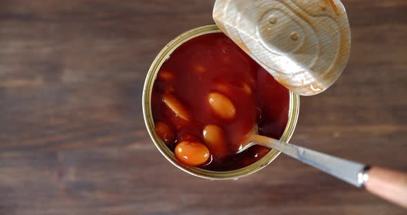 Tin Jar with Beans in Tomato Sauce on the Table. On a Wooden Background. 