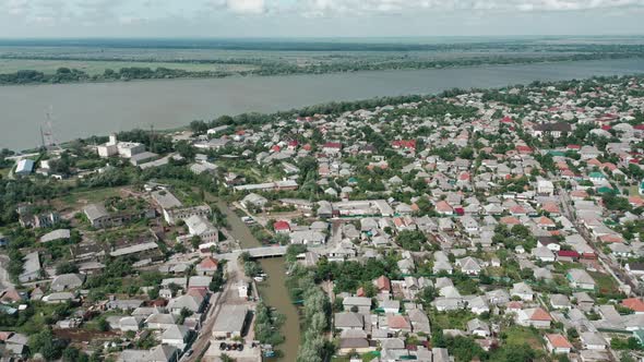 Aerial View of a Large Village By the River Against the Backdrop of a Cloudy Sky on a Summer Day