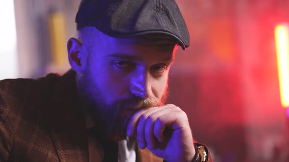 Handsome Bearded Man in a Tuxedo Sitting in Dark Room