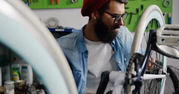 Mechanic repairing bicycle in workshop