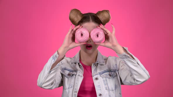 Girl Sniffs the Cake and Licks Her Lips. Pink Background. Slow Motion