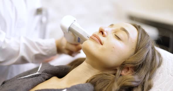 Woman on Ultrasound Face Lifting Procedure in Cosmetology Salon