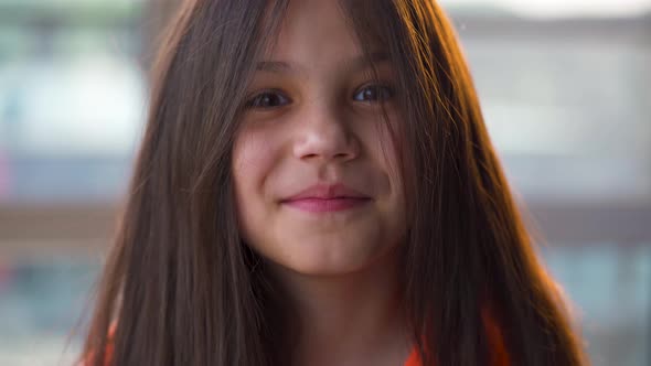 Portrait of a Brunette Girl Looking at the Camera and Smiling at Sunset