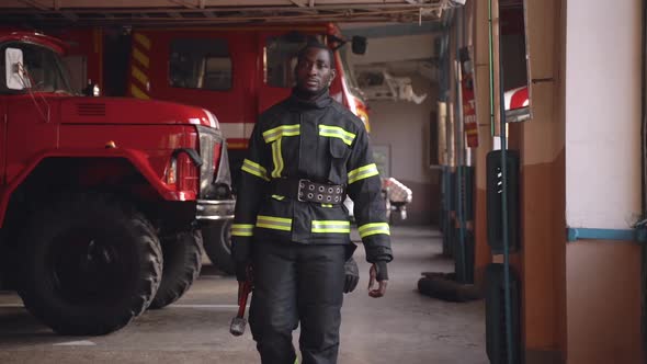 Black Fire Fighter Preparing for Emergency Call at the Station