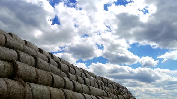 Time Lapse with White Clouds Floating Over a Large Big Haystack