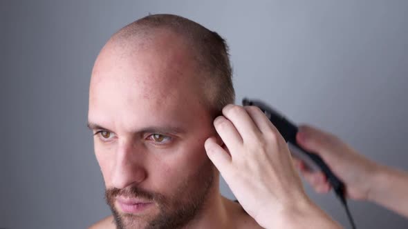 Hairdresser Shaves a Man Hair with a Hair Clipper.