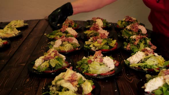 Close Up Chef Sprinkling Vegetable Salad with Parmesan for Serving on Restaurant Kitchen