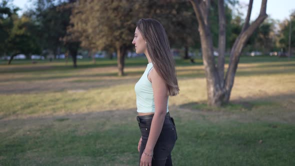 a Pretty Girl in Wide Shot in a Park Practicing Acting