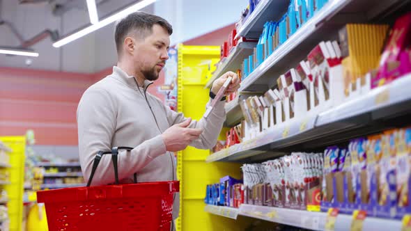 Man Choosing Chocolate Among the Great Variety of Its Types