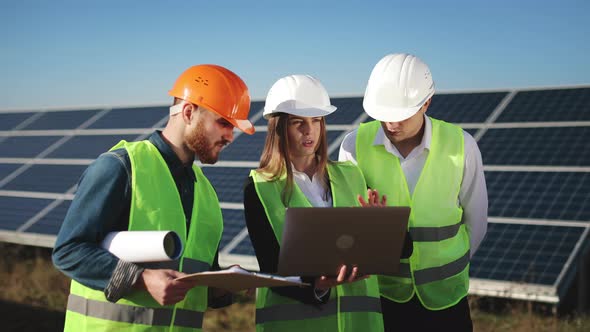 Three Engineers are Checking the Data with a Laptop and Discussing It