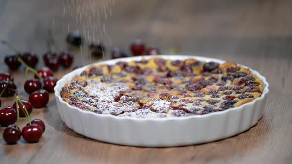 Cherry Clafoutis with powdered sugar in baking dishes