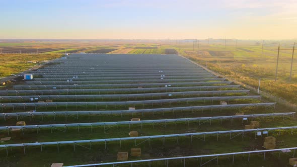 Aerial view of solar power plant under construction on green field. Assembling of electric