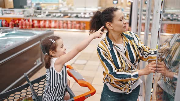 Mom and Daughter Buy Seafood at the Supermarket