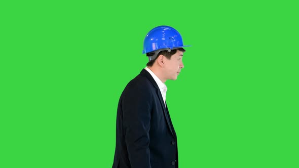 Bowing Young Asian Engineer in a Helmet and a Suit on a Green Screen Chroma Key