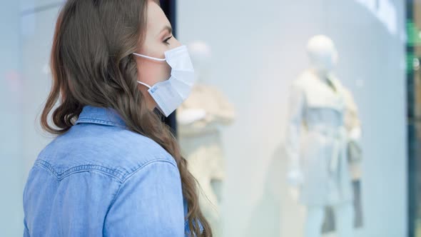 Video of woman in protective mask walking in shopping mall. Shot with RED helium camera in 8K.