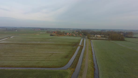 Drone Pan hover flight Over meadows to a small village in Europe The Netherlands, Friesland. Half cl