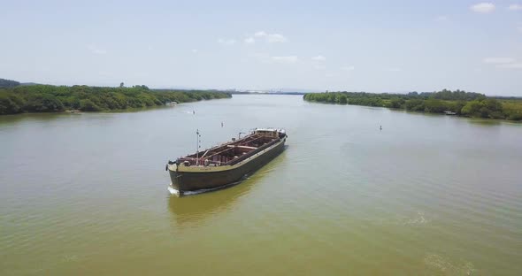 Large Barge traveling down Jacui River, Brazil. Wide Aerial Pan View