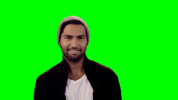 Smiling man standing against green screen