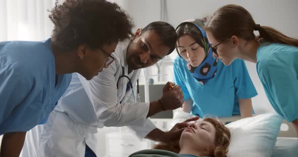 Tea of Residential Doctors Examining Patient in Emergency Room at Hospital