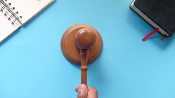 Top View of Person's Hand Striking the Gavel.