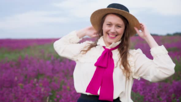 Girl in a Blue Dress with a White Blouse and a Straw Hat Walks Along