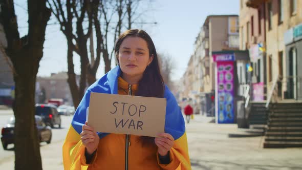 Portrait of a Sad Ukrainian Woman with a Ukrainian Flag and a Sign