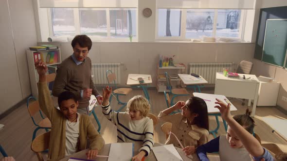 Students Raising Hands at Lesson in Classroom