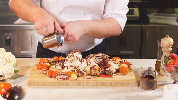 Chef Pouring or Sauce Over Chicken Dish Before Serving It To Customer.