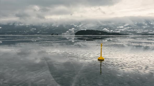 Yellow Special Mark Buoy On Frozen Steinsfjorden Lake With Clouds In Norway. - timelapse