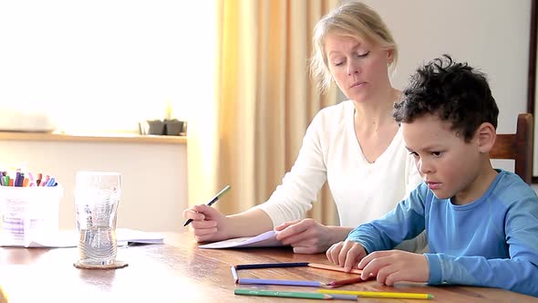 homework at home with mother and child doing homework on the table with pen and paper stock footage