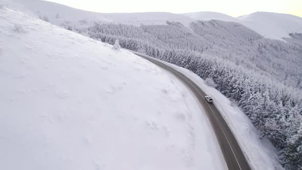 Drone Chasing SUV Speeding on Curvy Winter Mountain Road