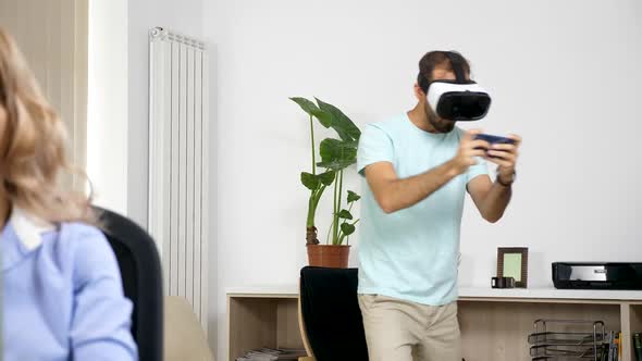 Man Plays Virtual Reality Games in the Living Room While Her Girlfriend Tries To Work on the