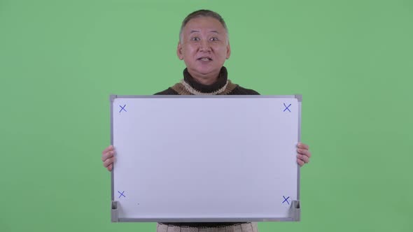 Happy Mature Japanese Man Talking While Holding White Board