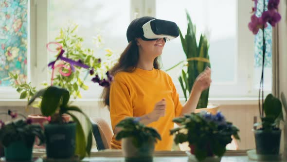 Smiling caucasian woman in VR glasses playing at virtual drums.