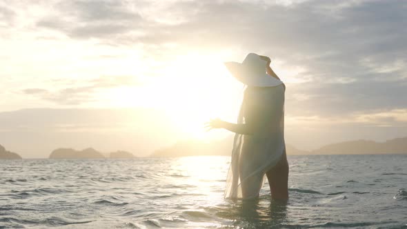 Woman In Thong In Sea At Sunset