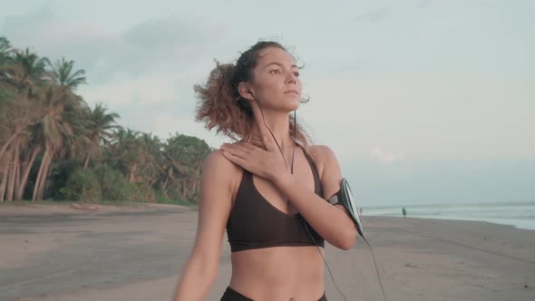 Woman Warming up Shoulder on Beach