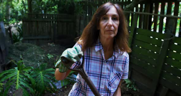 Mature woman using gardening fork in the garden 4k