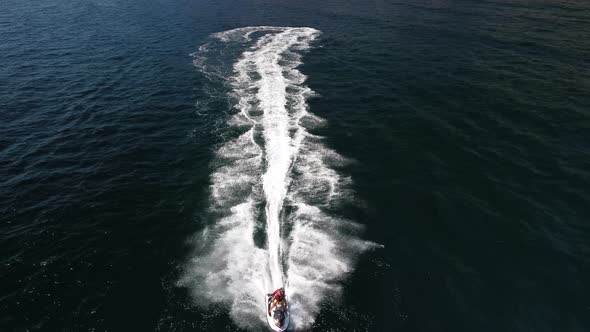 Happy People Swim on Air Mattress Behind a High Speed Water Bike