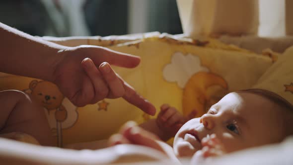 Close Up Shot of Baby's Little Cute Hand Reaching for Father's Loving Finger