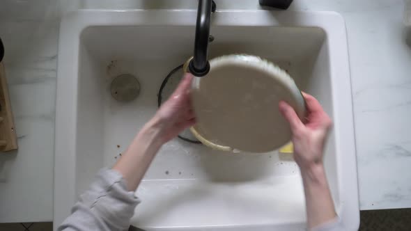 woman washes a dish at kitchen
