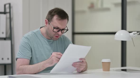 Young Man Reacting To Loss Documents
