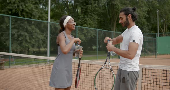 Multi Ethnic Couple Drink Water After Tennis Match