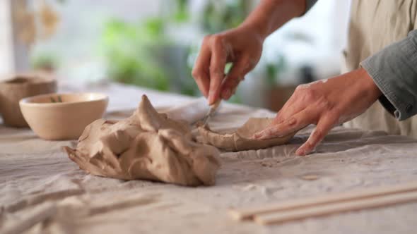 Female hands cutting clay