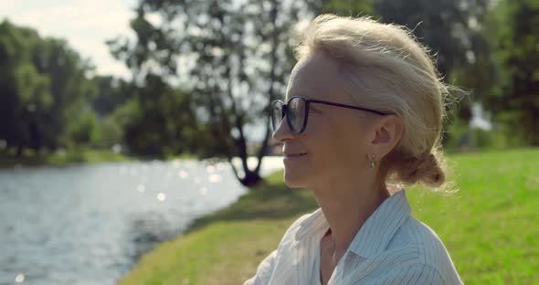 Close Up Portrait of Smiling Senior Woman Outdoors Near River